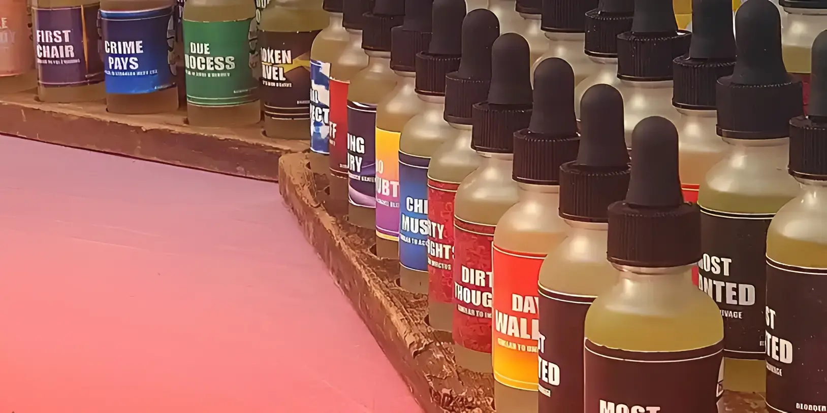 Row of colorful vape juice bottles with black droppers.